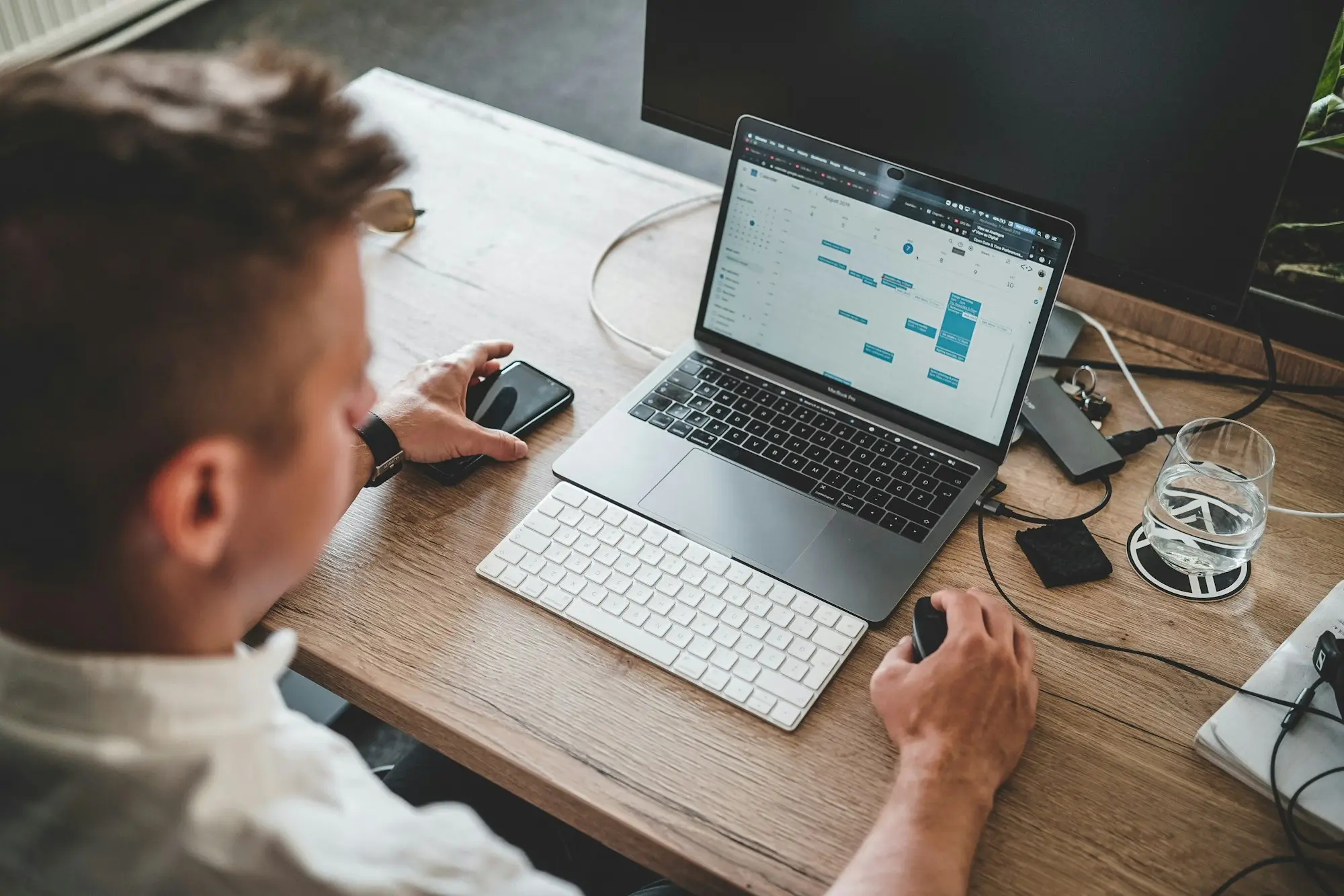 Man working through figures on a laptop and phone