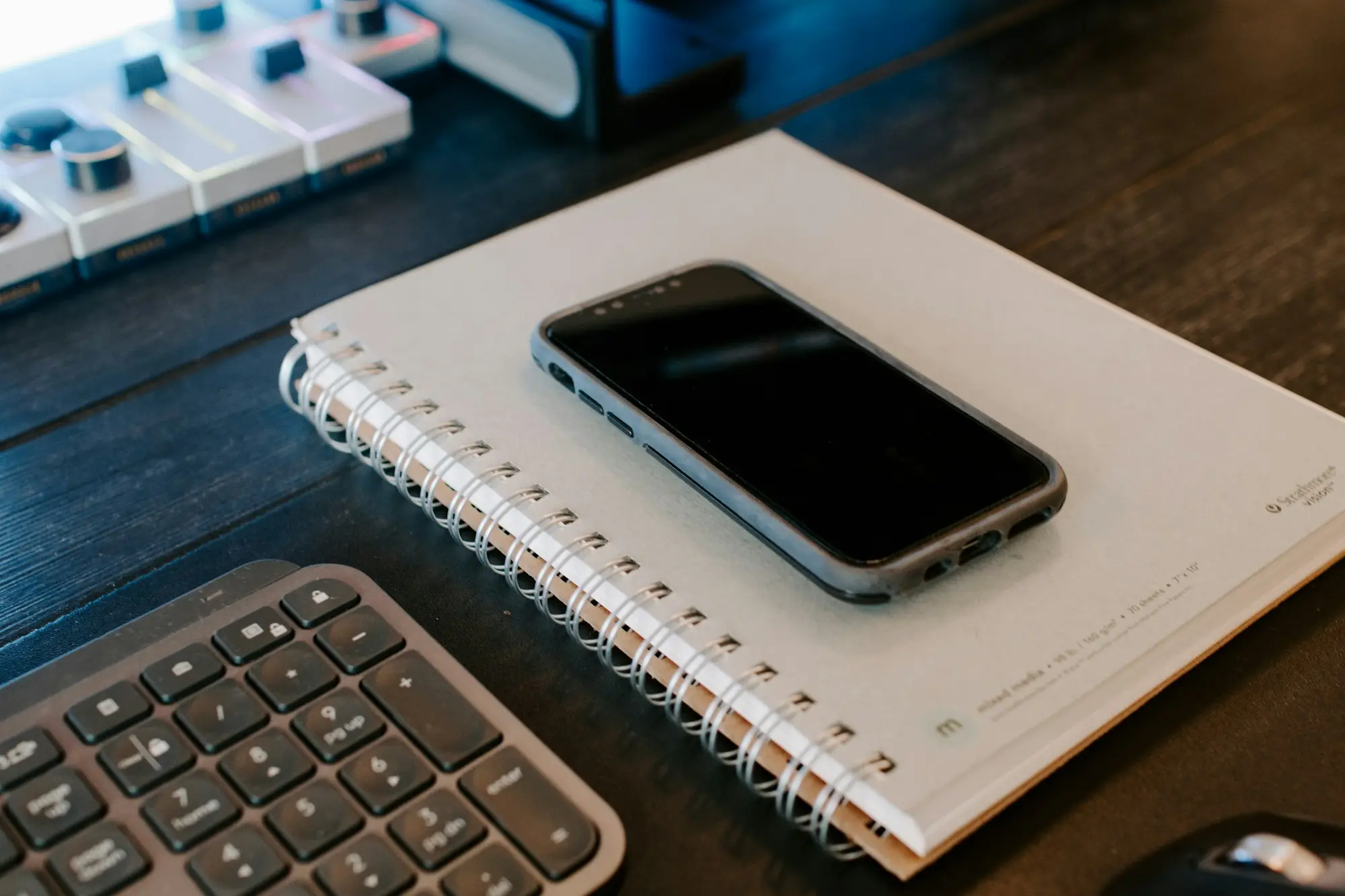 Phone on a notebook beside a keyboard
